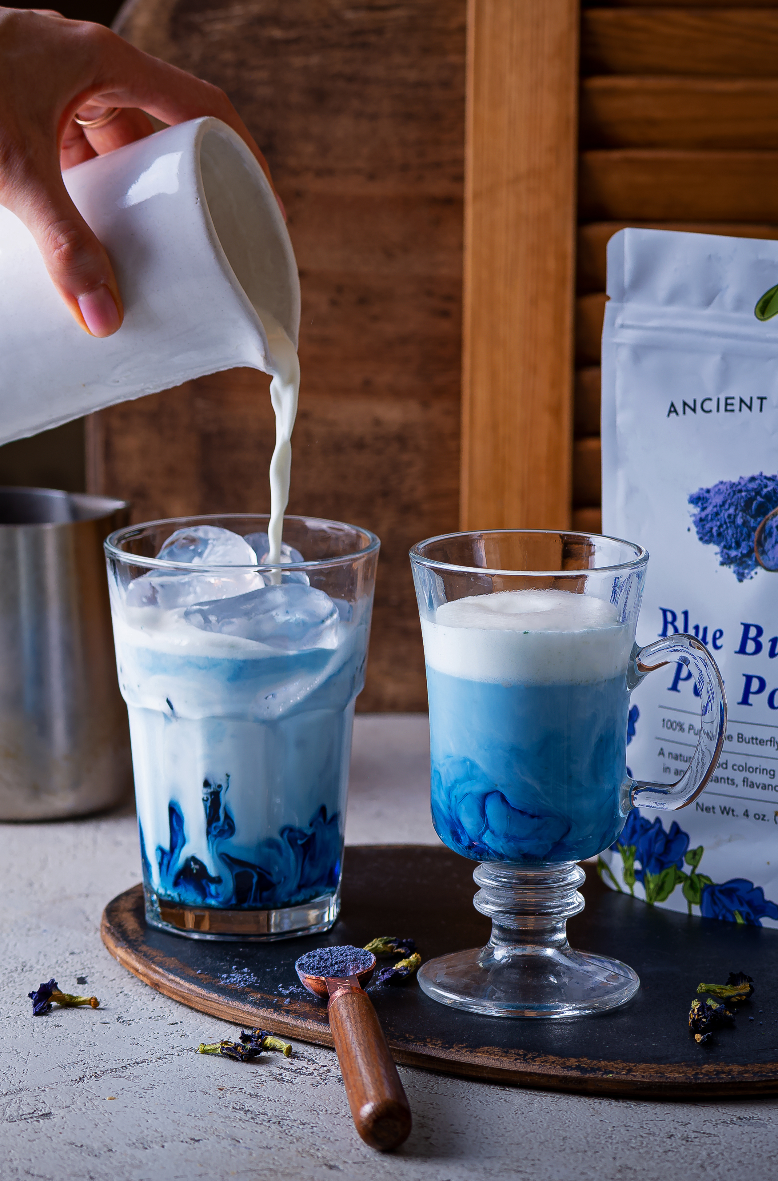 Pouring milk into a blue butterfly pea latte