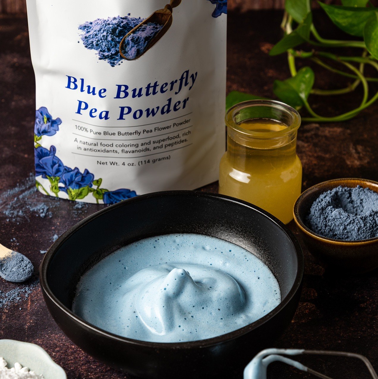 Butterfly Pea Flower Powder pouch with blue mousse and powder on dark surface