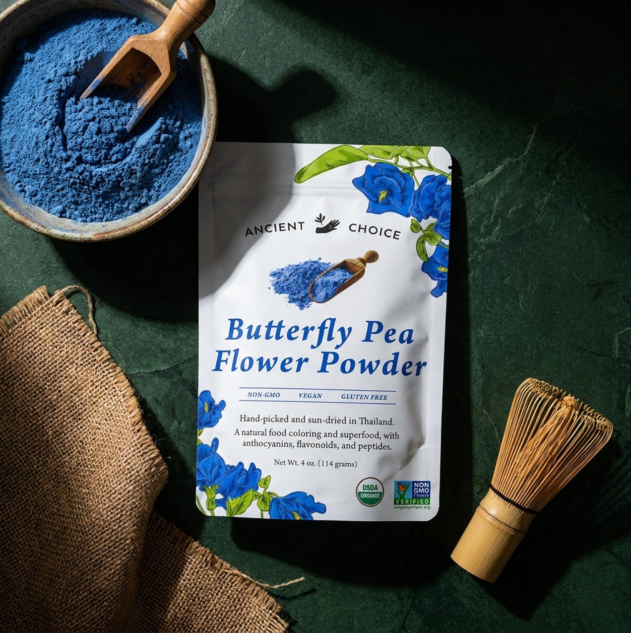 Butterfly Pea Flower Powder pouch with blue powder in a bowl on green marble