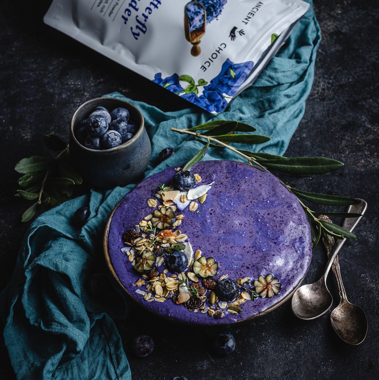 Violet butterfly pea smoothie bowl with blueberries and granola